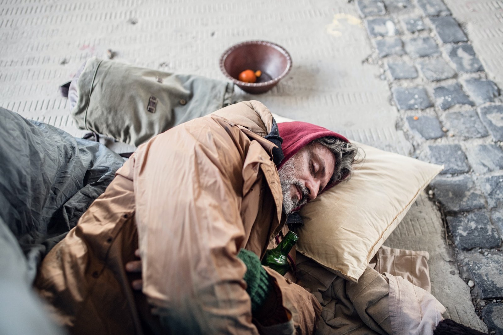 homeless-beggar-man-lying-on-the-ground-outdoors-in-city-sleeping-.jpg