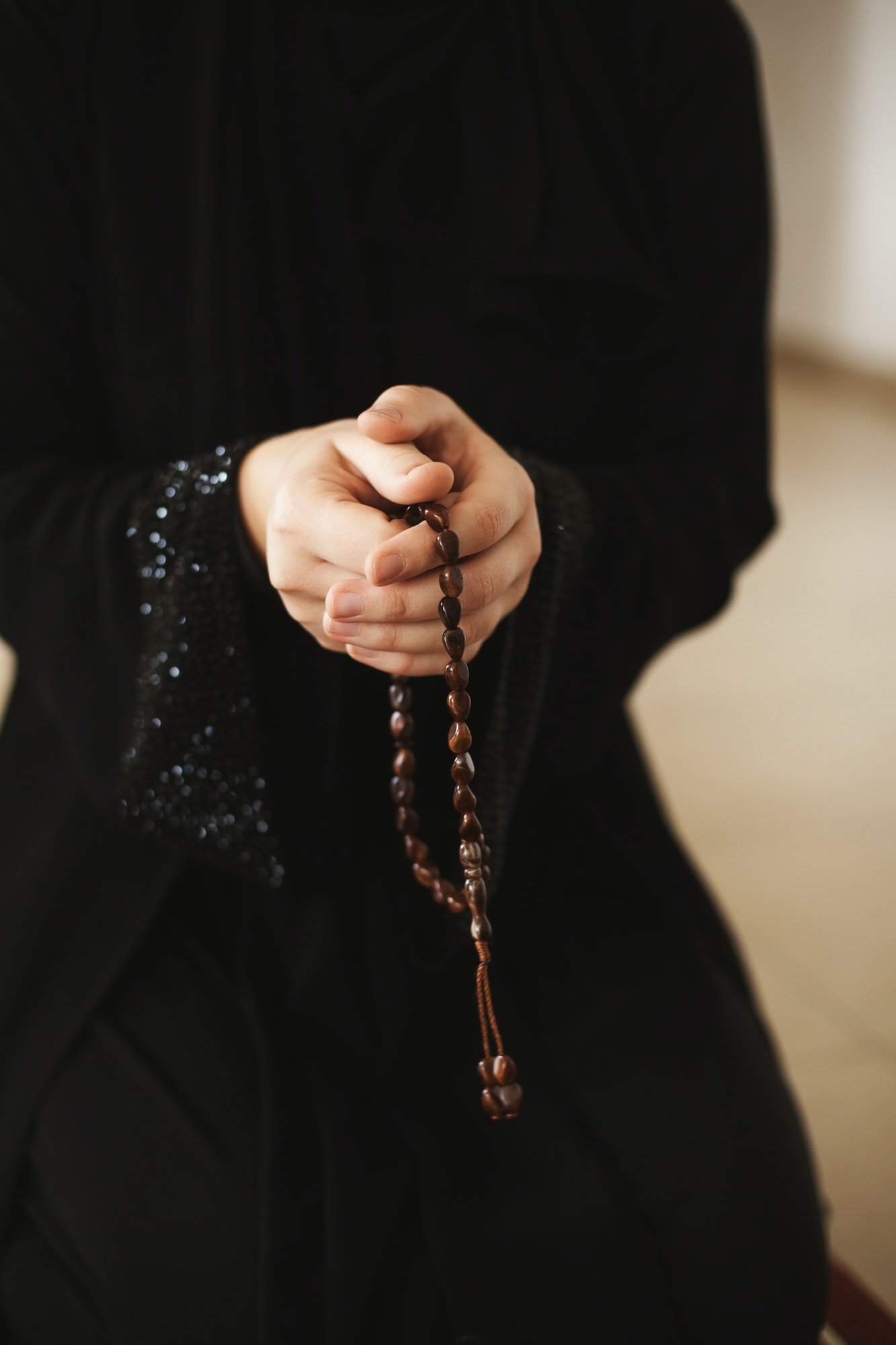 prayer-hands-of-a-woman-holding-a-rosary.jpg
